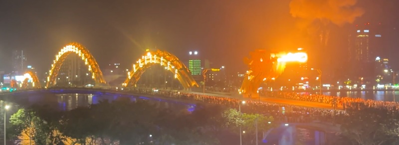 The Dragon bridge spitting fire, there is a huge crowd beneath the head of the dragon